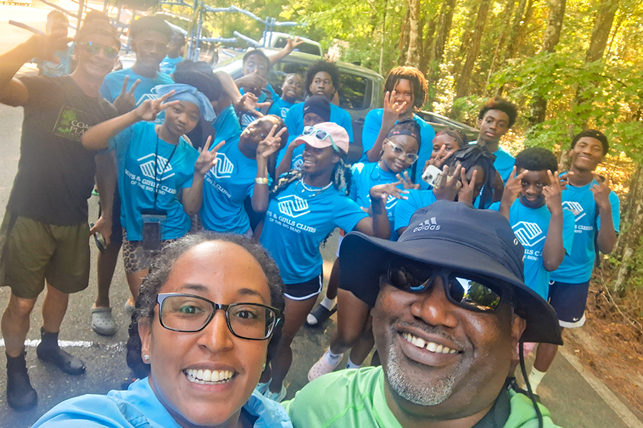 Amanda Tazaz with a colleague taking a group selfie with Boys and Girls Club participants
