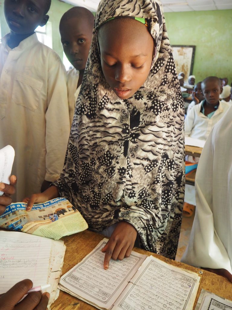 "Young female student in Nigeria reading from a book"