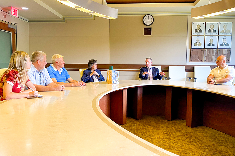 "SU President Richard McCullough and FSU Provost James Clark sittying at a large conference table meeting with the Ukrainian higher education leaders."
