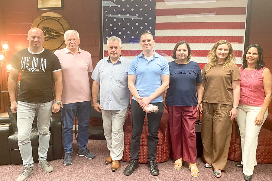 "Group photo in front of the USA flag at the FSU Student Veteran's Center"