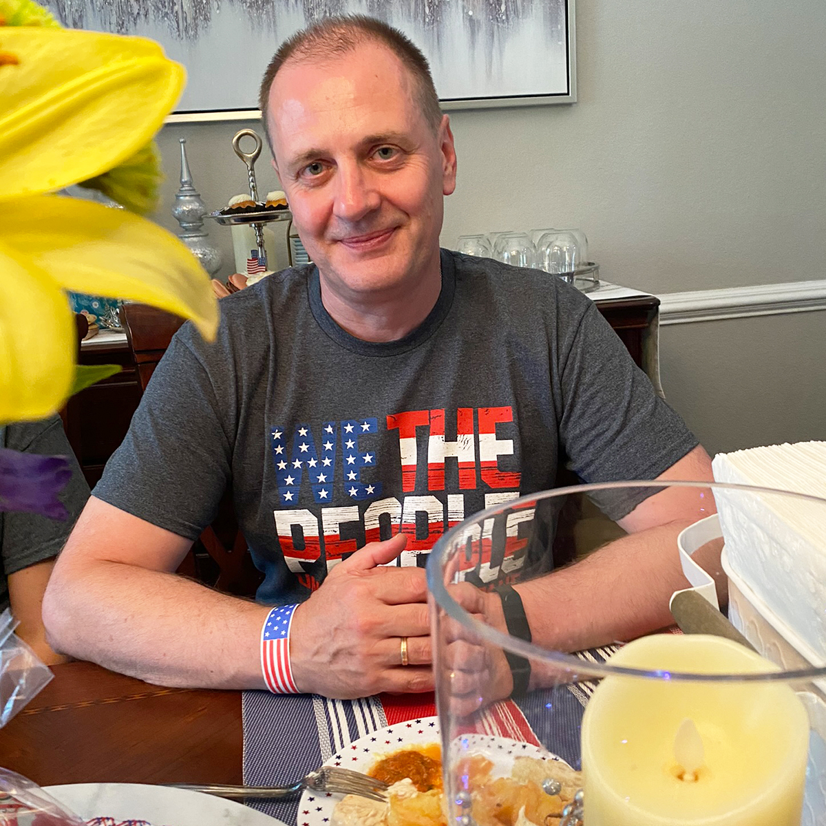 "Dr. Andrii Roskalda posing at a dining room table at a reception thrown for him and his colleagues."