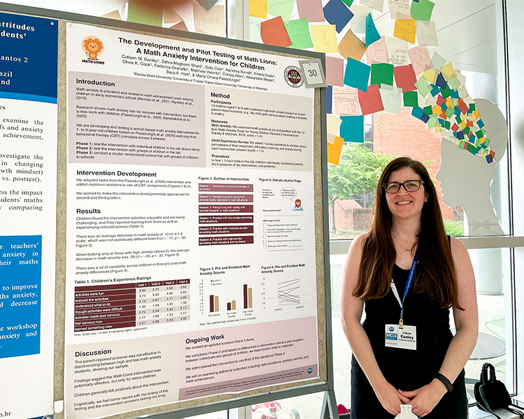 "Dr. Colleen Ganley standing next to her poster for the Math Lions project"