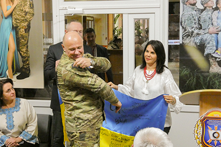 "Dr. Fuentes holds the Ukrainian flag while at the ceremony for the new veterans center in Khemylnitsky, which was built as a direct result of the work of FSU's UTF."