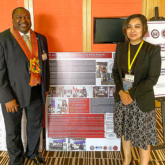 "Dr. Michelle Aguilar-Ong standing with a man next to a presentation poster."