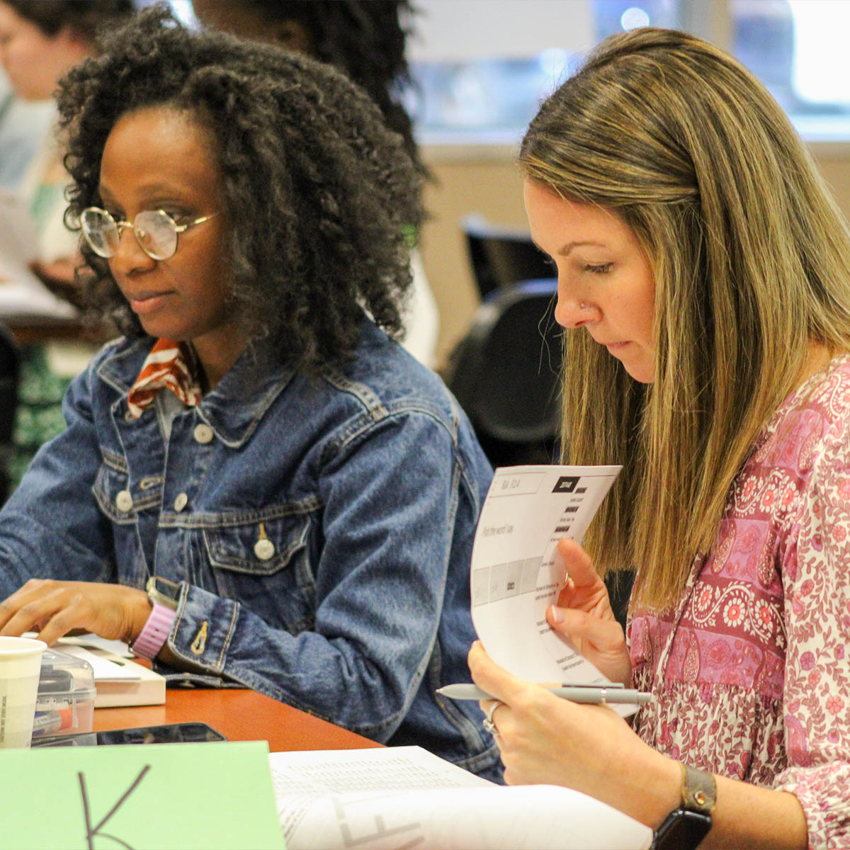 Two people working next to each during an math assessment writing workshop in Tallahassee.