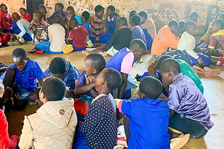 Students sitting in small groups in a classroom in Malawi.
