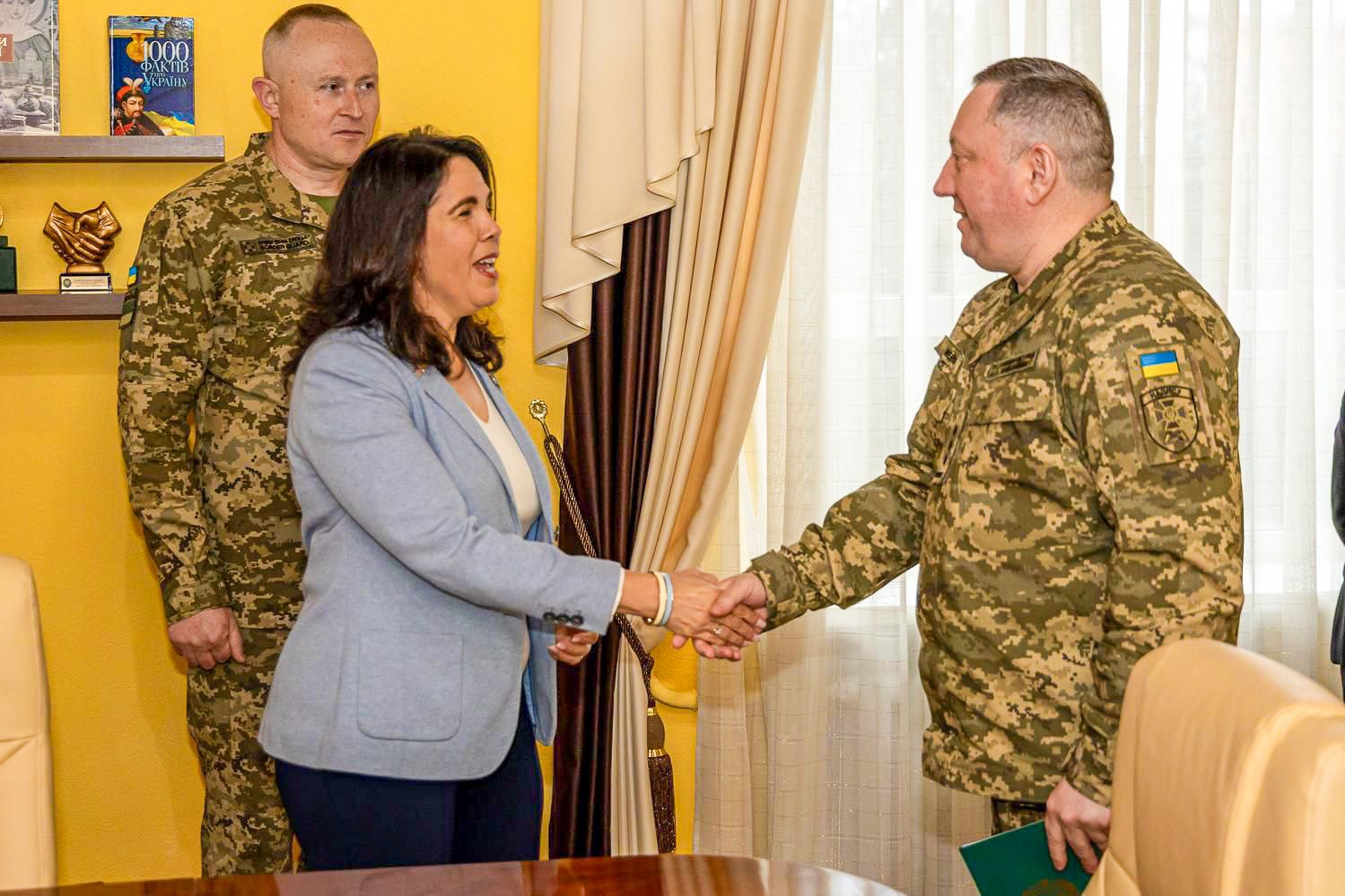 Vilma Fuentes shaking hands with a staff member from the National Academy of the State Border Guard Service in Khmelnytskyi, Ukraine.