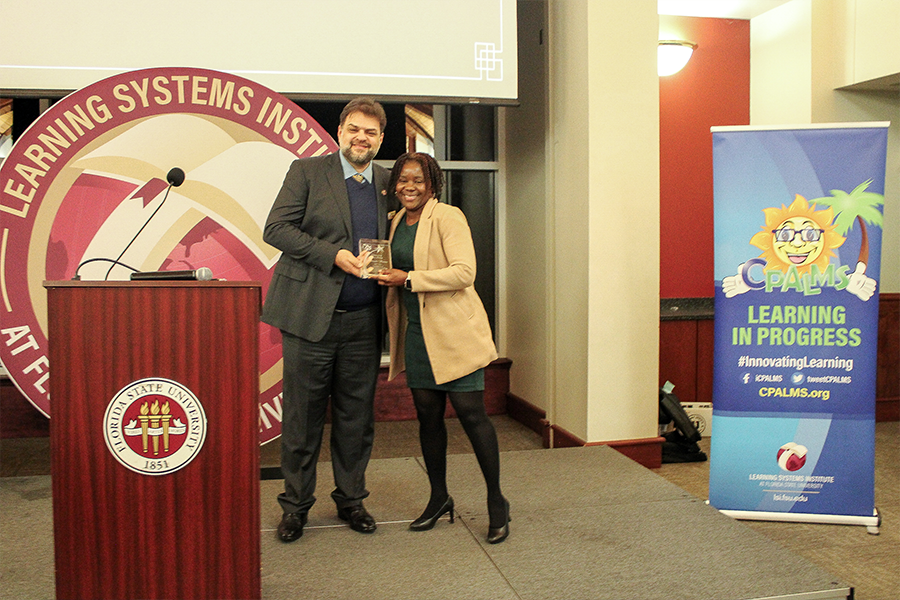 Brenda Wawire accepting an award from Rabieh Razzouk at an LSI banquet