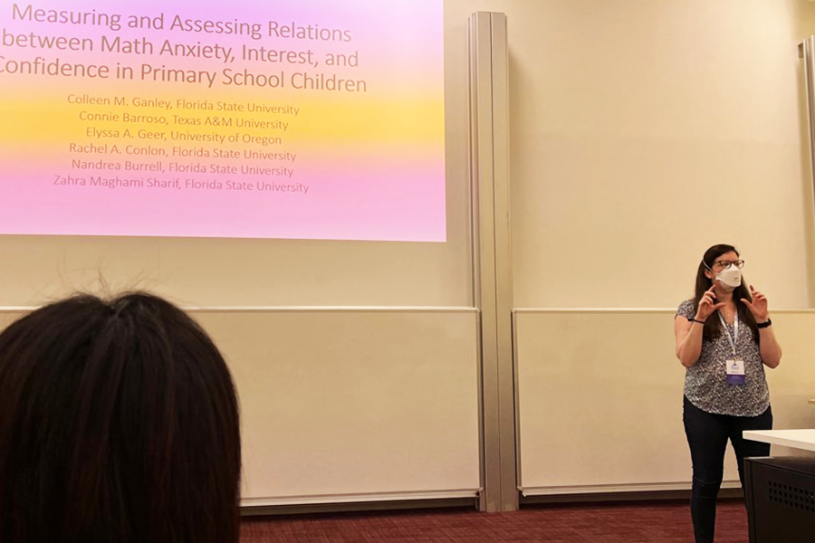 Colleen Ganley presenting in front of a large projection screen