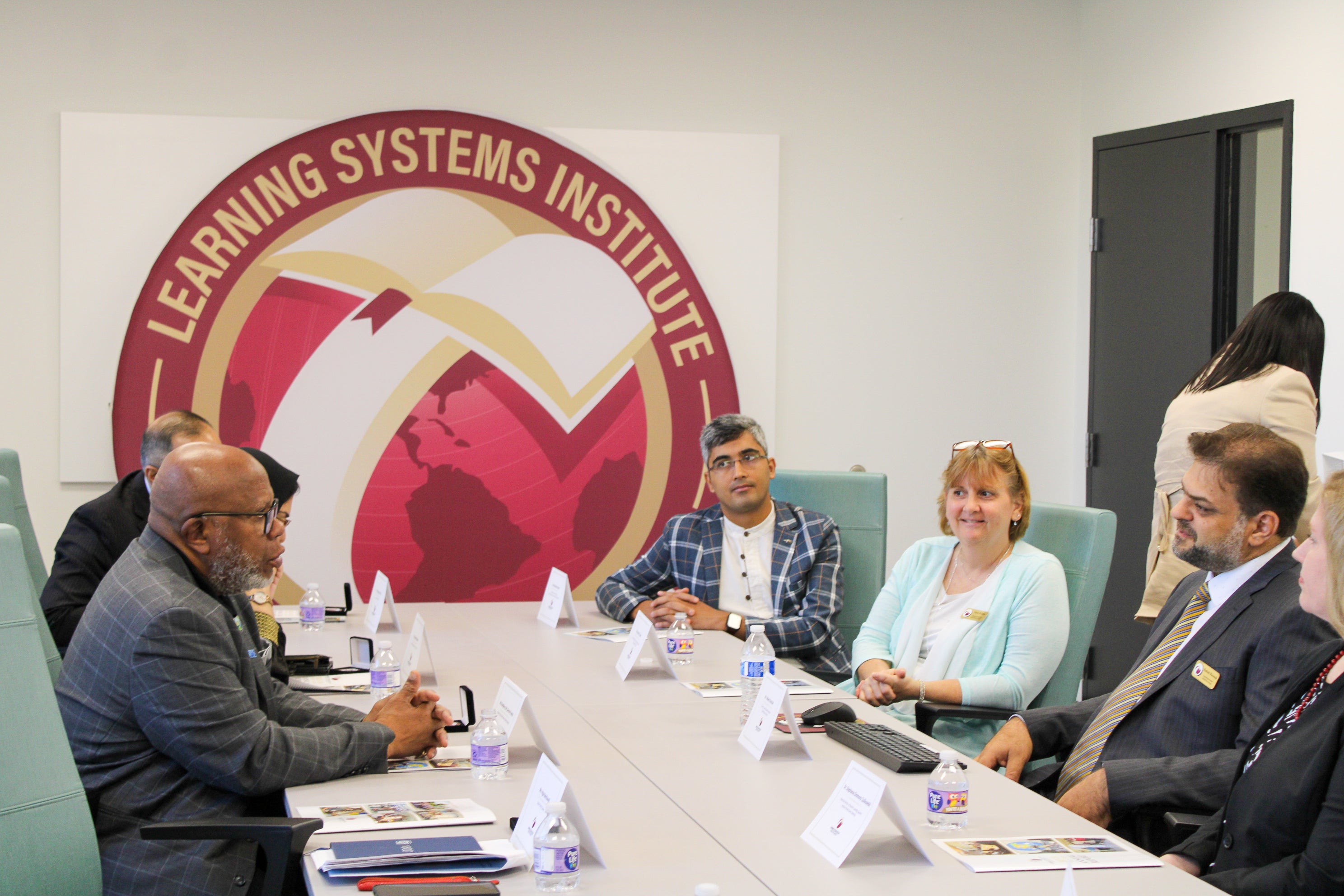 Rabieh Razzouk in a conference room meeting with a group including the UN President of the General Assembly. 