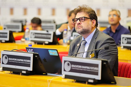Rabieh Razzouk at a desk at Educators Shaping Futures conference. 