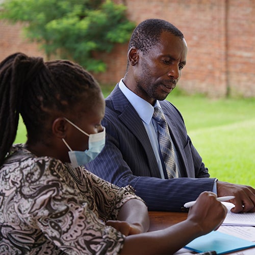 "Two people sitting at a table looking over paperwork"
