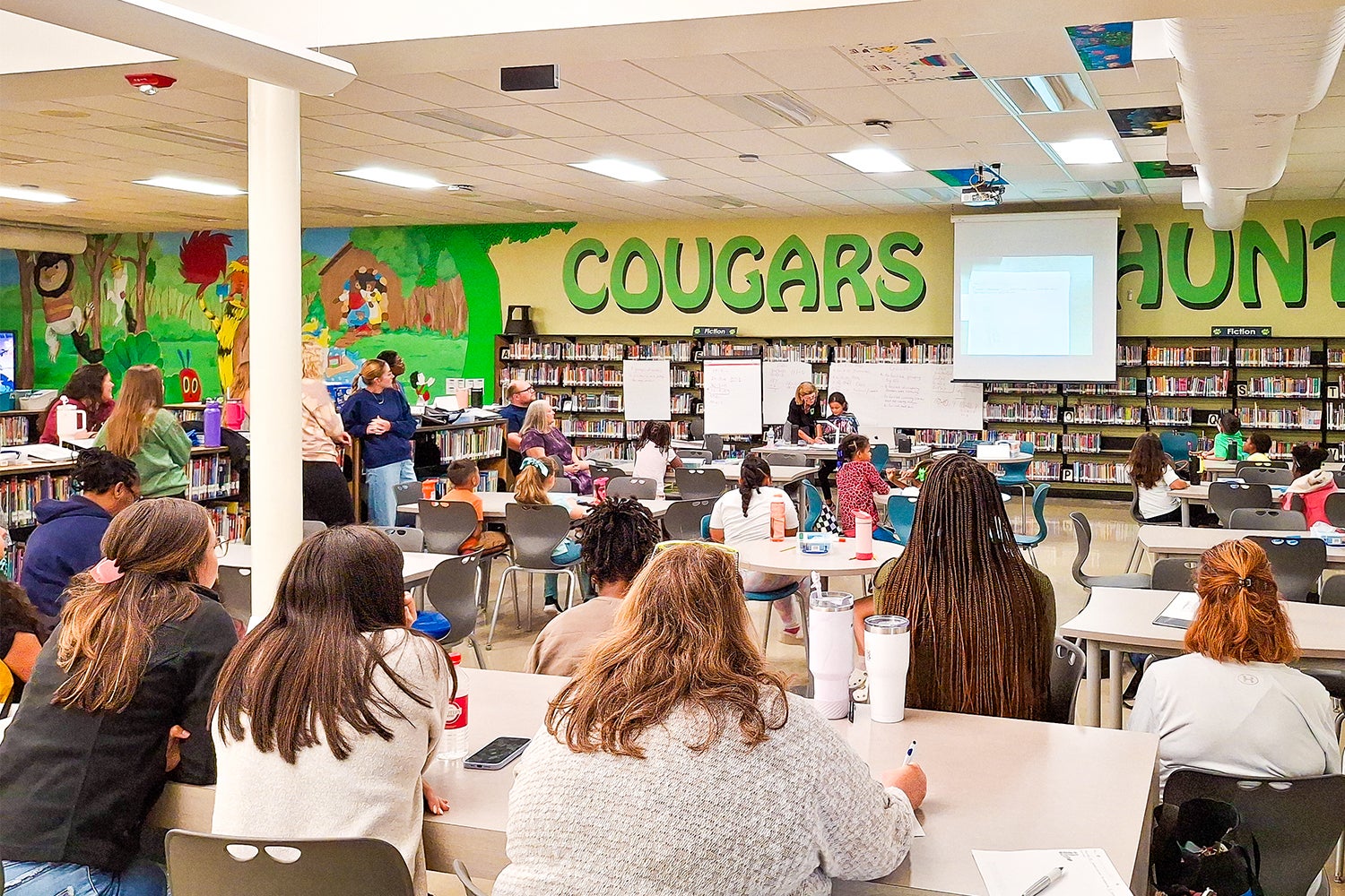 "Large classroom with people looking at a demonstration at the front of the room"