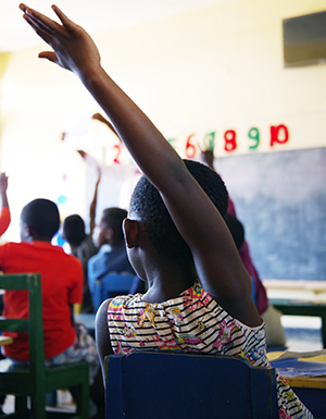 "Photo of a child raising their hand in a classroom in Rwanda"