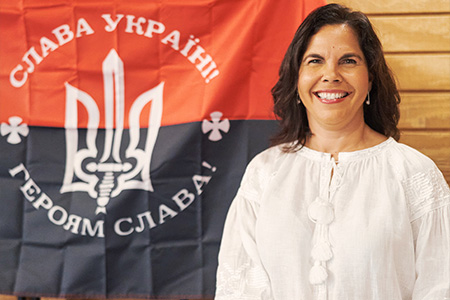 "Dr. Fuentes posing in front of a flag representing Ukraine"