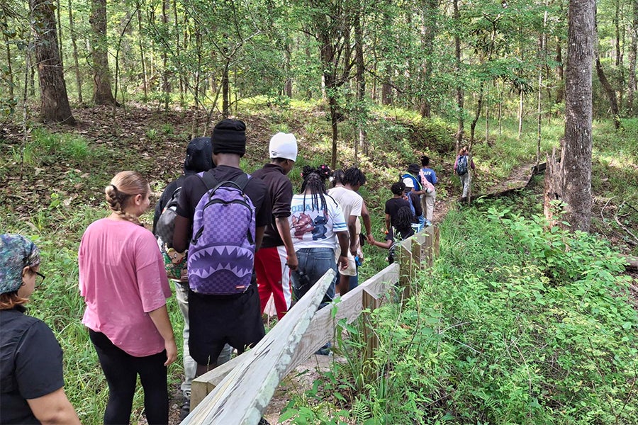 A group of student hiking through the forest.