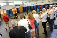 A line of people watching an instructor overseeing a tactical training drill