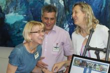 Candid photo of three people with two laughing