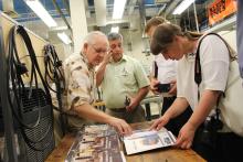One of the presenters showing a small group something in a book