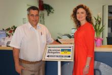 Two CCAP Ukraine group members posing by a sign for the Ukrainian delegation