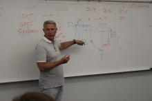 A man writing on a white board 