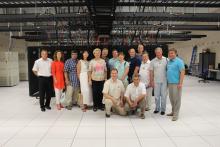 Group photo in front of a large bank of servers