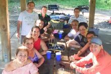 Large group of people around a picnic table 