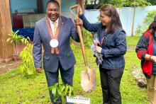 The President of Santa Fe College is holding up a shovel with a woman in front of a sign with his name