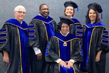 Five people all in graduation robes