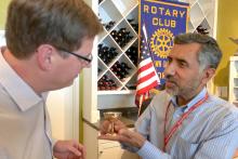 CCAP Pakistan group member presenting a small cup to a man at the Rotary Club