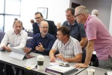 Group of people in discussion around a laptop