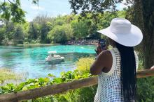 A  member of the CCAP South Africa taking a photo of a boat in one of Florida's natural springs