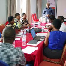 Group sitting at a table with laptops as part of the USAID Tunoze Gusoma (Schools and Systems) Activity