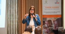 Dr. Ana Marty with a microphone speaking to a group in Rwanda. 