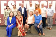 Group photo in front of a large Research banner. 