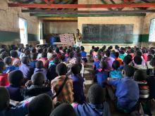 Teacher standing in front of a large classroom of children in Malawi.
