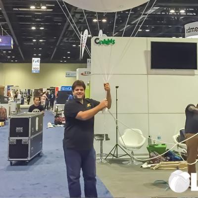 LSI Director Rabieh Razzouk holding a large balloon with the CPALMS logo on it inside an exhibition hall.