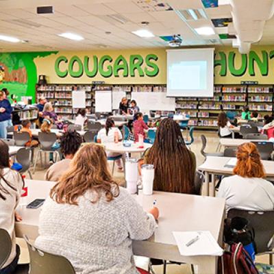 Large classroom with people looking at a demonstration at the front of the room