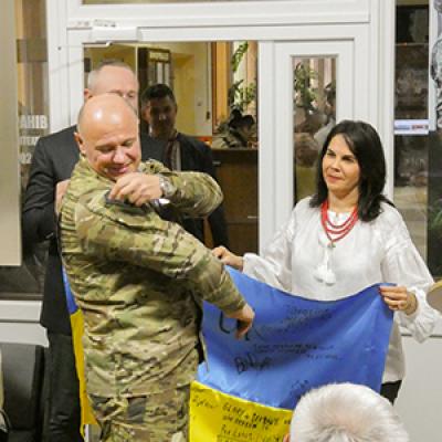Dr. Fuentes holds the Ukrainian flag while at the ceremony for the new veterans center in Khemylnitsky, which was built as a direct result of the work of FSU's UTF.