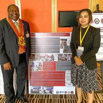 Dr. Michelle Aguilar-Ong standing with a man next to a presentation poster.