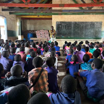 Teacher standing in front of a large classroom of children in Malawi.
