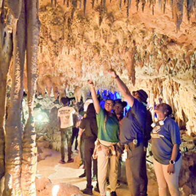 A group outing inside a Florida cavern as participants explore stalactite and stalagmite,