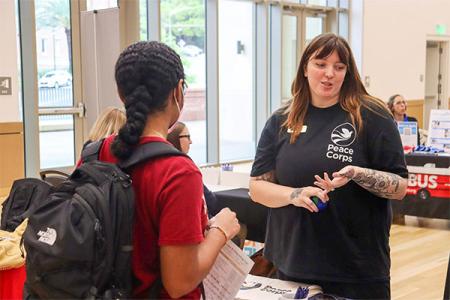 Peace Corps recruiter at Florida State University talking with a student at a career fair.