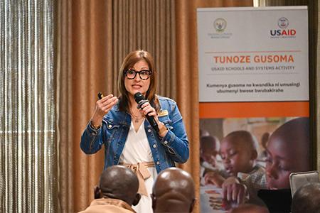 Dr. Ana Marty standing addressing a group with a microphone. 