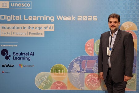 Rabieh Razzouk posing infront of UNESCO Digital Learning Week 2026 backdrop