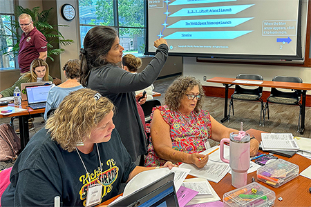 Instructor in a classroom working with teachers.